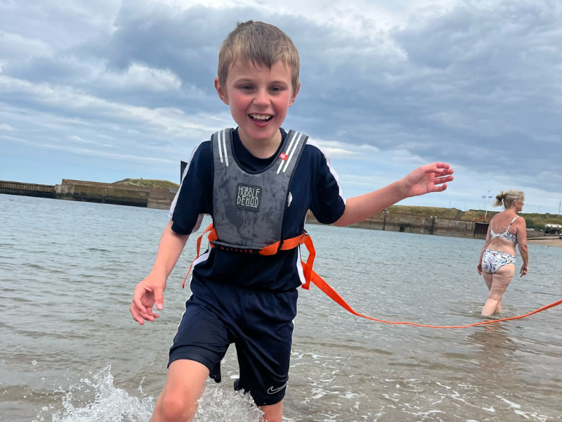 Angus paddling in the sea, smiling